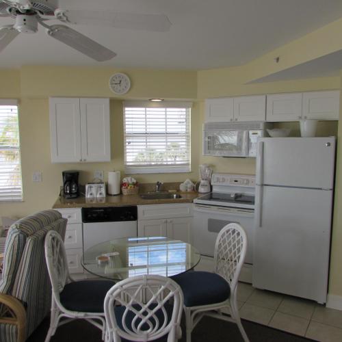 a kitchen with a white refrigerator and a table and chairs at Edison Beach House in Fort Myers Beach