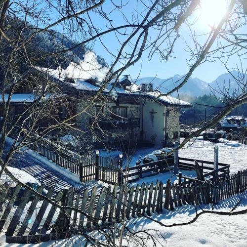 a fence in front of a house in the snow at Maso Franceschella in Carano