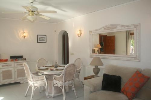 ein Wohnzimmer mit einem Tisch und einem Stuhl in der Unterkunft Las Bellotas in Moraira