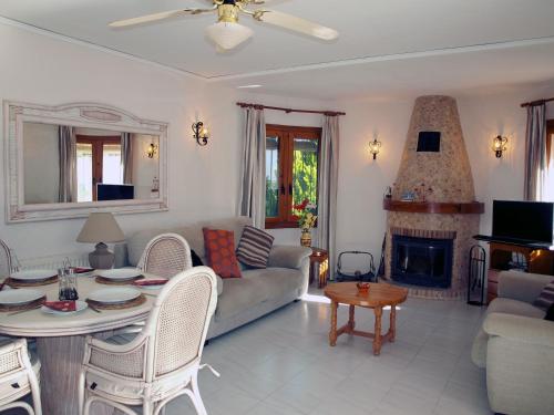 ein Wohnzimmer mit einem Sofa, einem Tisch und einem Kamin in der Unterkunft Las Bellotas in Moraira