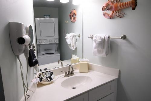 a white bathroom with a sink and a mirror at Edison Beach House in Fort Myers Beach