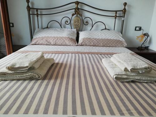 ein Bett mit zwei Kissen und Handtüchern darauf in der Unterkunft Gio Horses B&B in Sannicandro Garganico