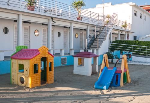 a playground with play equipment in front of a building at Hotel Biagi & Residence in Lido di Camaiore