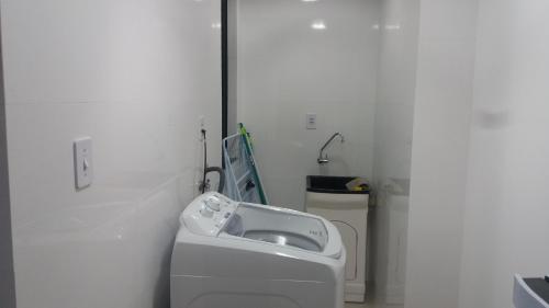 a white bathroom with a sink and a toilet at Apartamento Ed. London in Piratuba