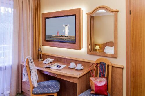 a hotel room with a desk and a mirror at Hotel Polaris III in Świnoujście
