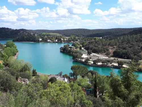 an aerial view of a lake with trees and houses at El Mirador De Ruidera in Ruidera
