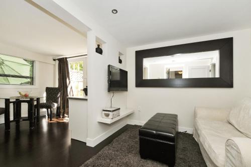 a living room with a couch and a tv on a wall at The Craigmyle Inn in Victoria