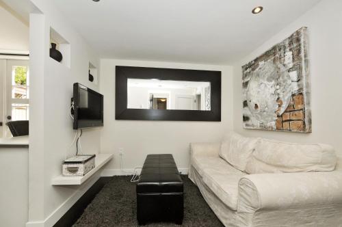 a living room with a white couch and a tv at The Craigmyle Inn in Victoria