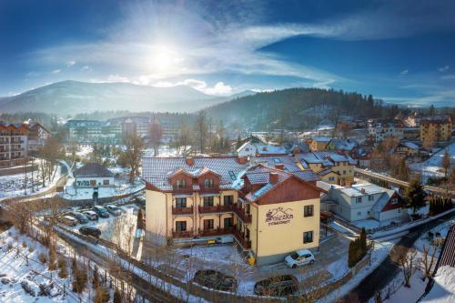 a city with snow on the roofs of buildings at Pensjonat Śnieżka SPA in Karpacz