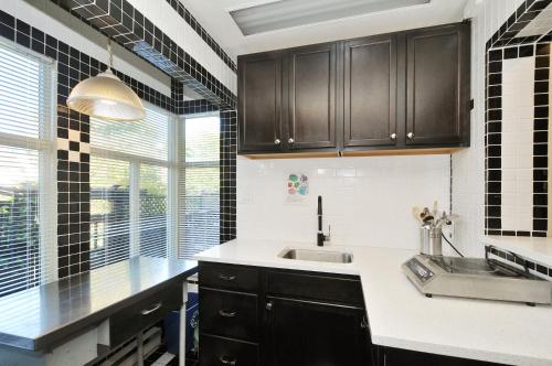 a kitchen with black cabinets and a sink at The Craigmyle Inn in Victoria