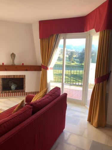 a living room with a red couch and a large window at La Siesta de Mijas Golf 174 in Fuengirola
