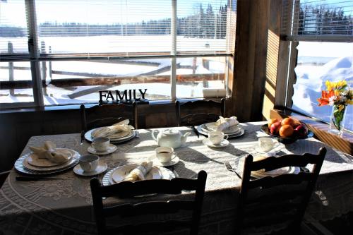 a dining room table with a view of a snow covered at Woodhouse Cottages And Ranch in Prince George