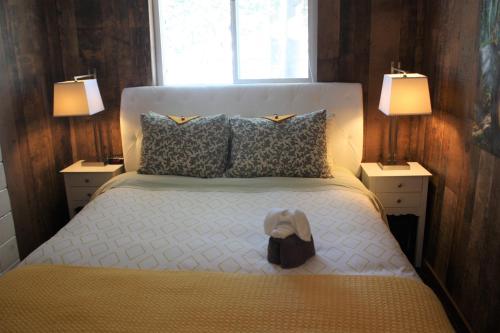 a bedroom with a bed with a hat on it at Woodhouse Cottages And Ranch in Prince George