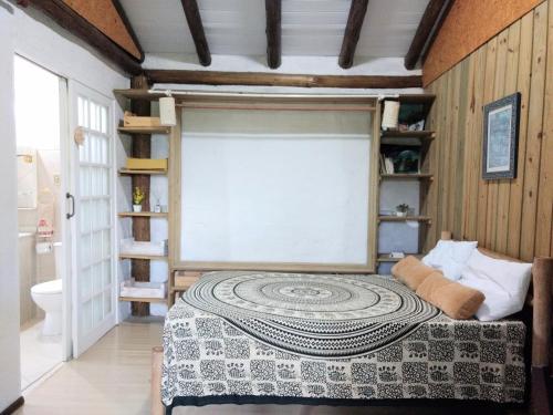 Un dormitorio con una cama con una alfombra grande. en Chalé do Tibet Vale da Utopia, en Guarda do Embaú