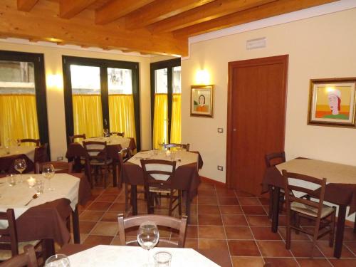 un ristorante con tavoli e sedie in una stanza di Agriturismo Cascina Rossano a Provaglio d'Iseo