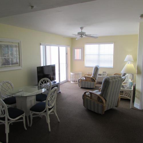 a living room with a table and chairs and a television at Edison Beach House in Fort Myers Beach