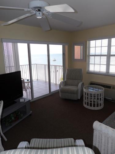 a living room with a couch and a chair and a television at Edison Beach House in Fort Myers Beach