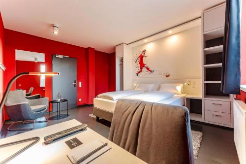 a bedroom with a bed and a desk with a computer at Hotel Athletik Kiel in Altenholz