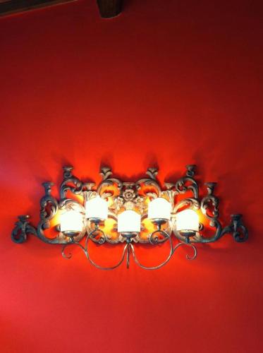 a chandelier is hanging from a red wall at Capri Moon Guest House in Florence