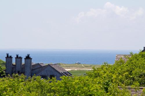 a house on a hill with the ocean in the background at The Seaglass Inn & Spa in Provincetown