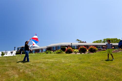 two people are flying a kite in a field at The Seaglass Inn & Spa in Provincetown