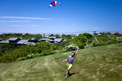 a person is flying a kite in a field at The Seaglass Inn & Spa in Provincetown