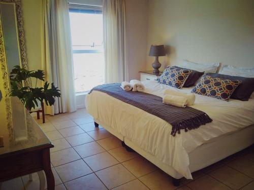 a bedroom with a bed with two stuffed animals on it at Harbour Views in Simonʼs Town