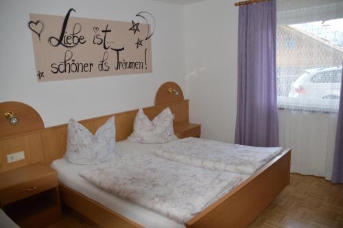 バルビアーノにあるHaus Hoferのベッドルーム1室(壁に看板付)
