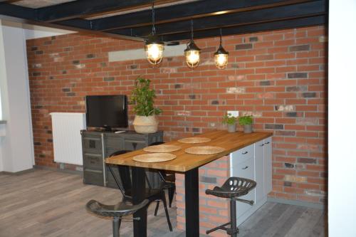 a table in a room with a brick wall at LoftStyle Apartament in Żyrardów