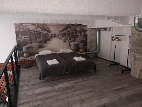 a bedroom with a bed and a painting on the wall at LoftStyle Apartament in Żyrardów