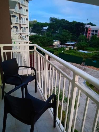 a balcony with a chair and a view of a city at Amani Grand Resort Residences near Mactan Cebu Intl Airport in Mactan