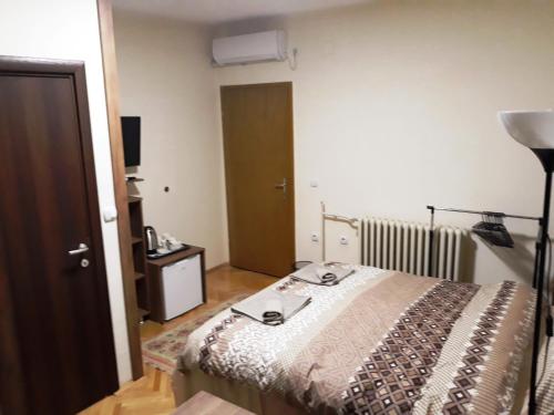 a bedroom with a bed and a lamp and a door at Villa Domina in Gevgelija