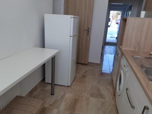 a kitchen with a white refrigerator and a sink at Apartman YVET in Sučany
