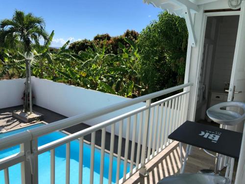 a balcony with a view of a swimming pool at Bungalow Akwarel in Vieux-Habitants