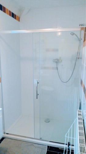 a shower with a glass door in a bathroom at Marine Lake apartment in West Kirby