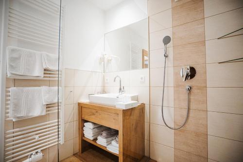 a bathroom with a sink and a shower at Apartmenthaus Strasswirt De Luxe in Tröpolach
