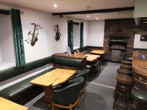 a restaurant with tables and chairs and a fireplace at Y Giler Arms in Pentrefoelas