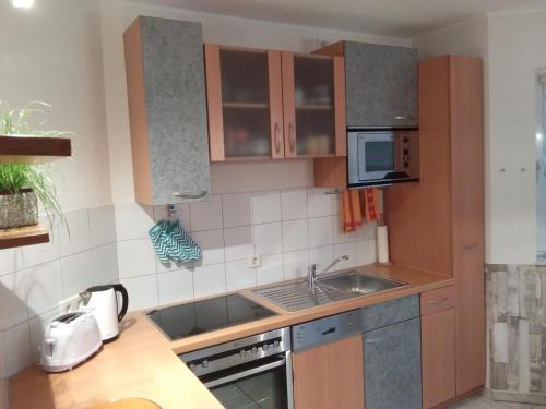 a small kitchen with a sink and a microwave at Ferienwohnung Erlenhof in Engelskirchen
