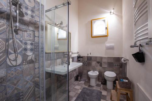 een badkamer met een douche, een wastafel en een toilet bij La stanza del Vicolo in Palermo