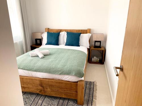 a bedroom with a bed with blue and white pillows at Home Crowd Luxury Apartments- Hamilton House in Doncaster