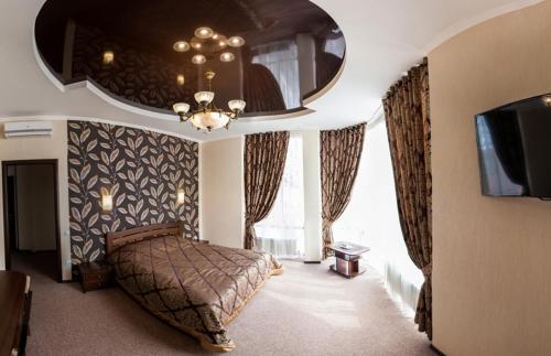 a large bedroom with a bed and a tv at Отель "София" in Vinnytsya