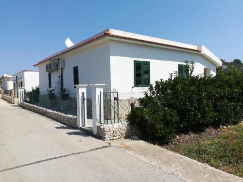 a white house with a fence in front of it at Villini Giovanna Disanti in Vieste