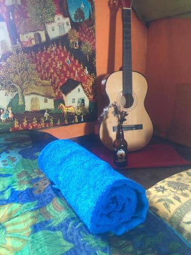 a blue blanket on a bed next to a guitar at cabopolonioalojamiento in Cabo Polonio