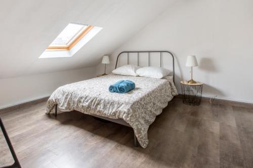 een slaapkamer met een bed met een deken en een raam bij Cosy appartement proche Gares in Lille
