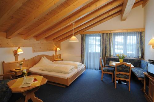 a hotel room with a bed and a desk at Hotel Camona & Apart Walserhof in Samnaun