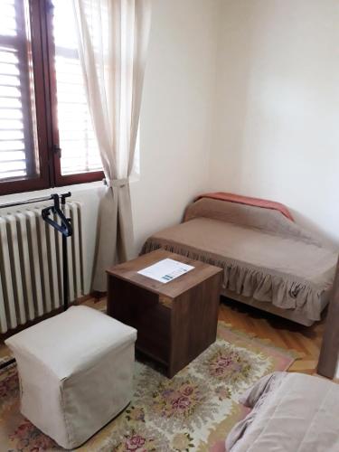 a room with two beds and a table and a chair at Villa Domina in Gevgelija