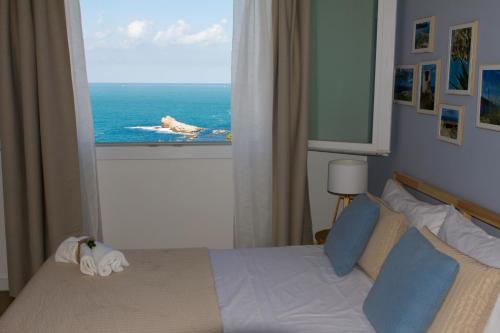 a bedroom with a bed with a view of the ocean at Zabbàra B&B in Terrasini