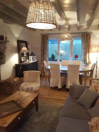 un salon avec une table et une salle à manger dans l'établissement le gite de sandrine, à Réville
