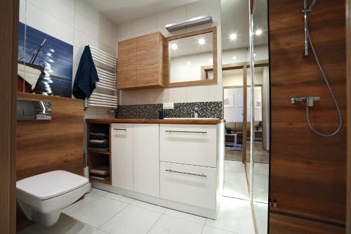 a bathroom with a toilet and a shower at Sea Haven - Morska Przystań in Jelitkowo