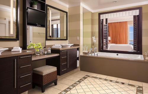 uma casa de banho com uma banheira e um espelho grande em The Residences on Siesta Key Beach by Hyatt Vacation Club em Sarasota